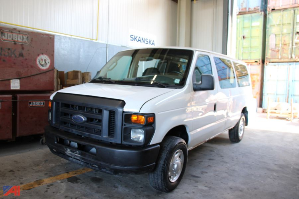 Ford E-250 van in a warehouse setting showing front grille and side profile.