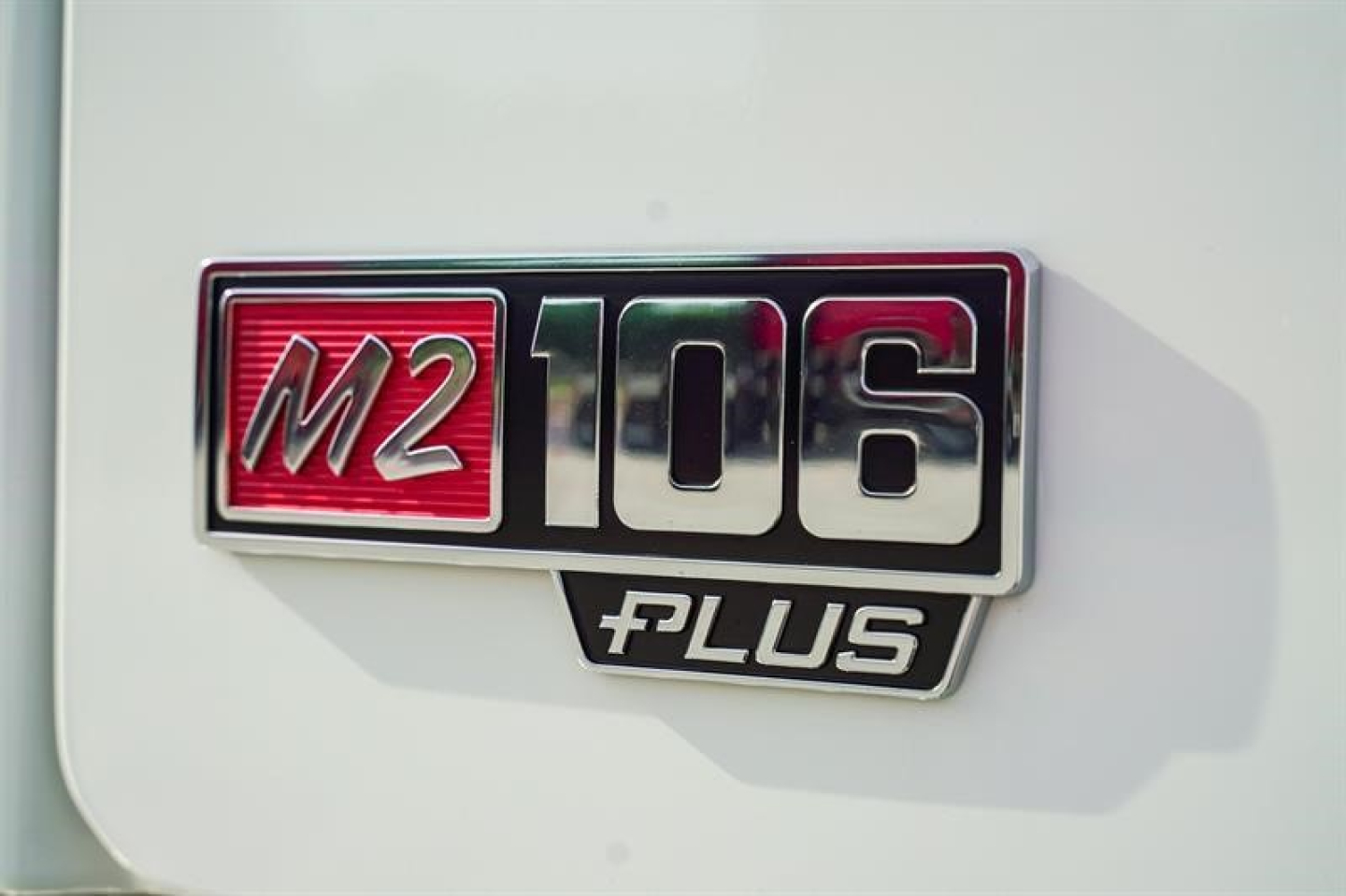 Freightliner M2 106 Plus emblem badge on white truck exterior showing M2 106 Plus insignia.