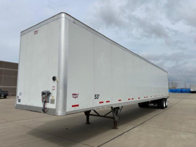 Trailer side view showing a 53' white Wabash dry van trailer with front nose, landing gear, and wheelset in a parking lot.