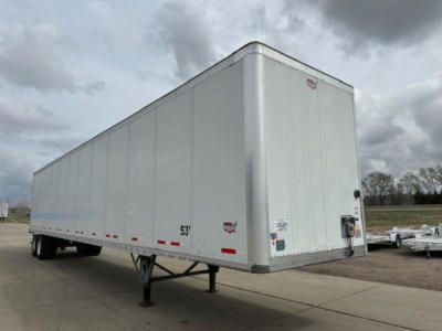 Trailer side view showing a 53' Wabash van trailer with rear and side stickers and a hitch area.