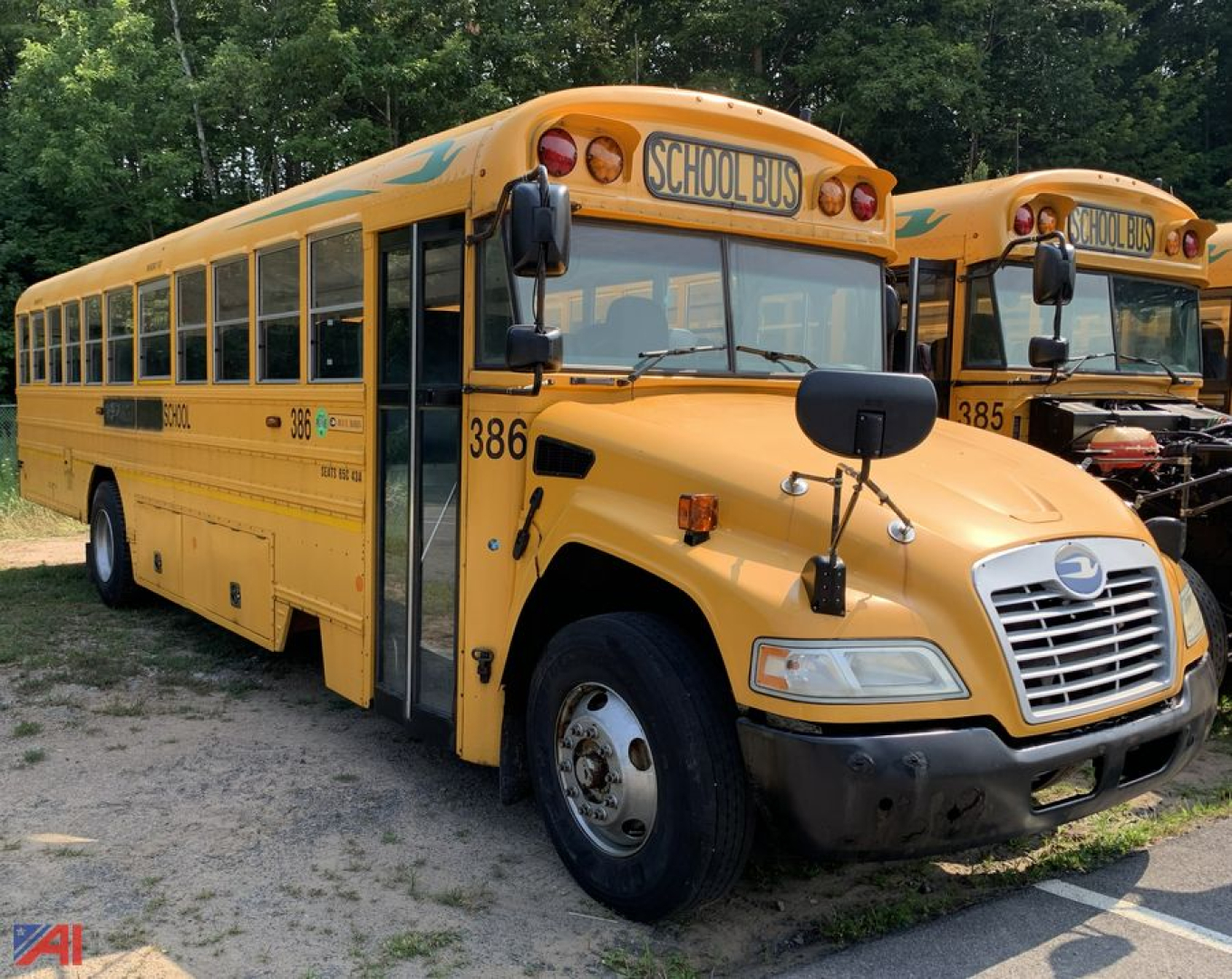 Yellow school bus front and side view showing School Bus signage, hazard lights, and bus decals.