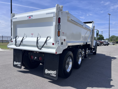 Dump truck rear three-quarters view showing rear gate, dual rear axles with six tires, and mud flaps labeled Bruckner's Equipment.