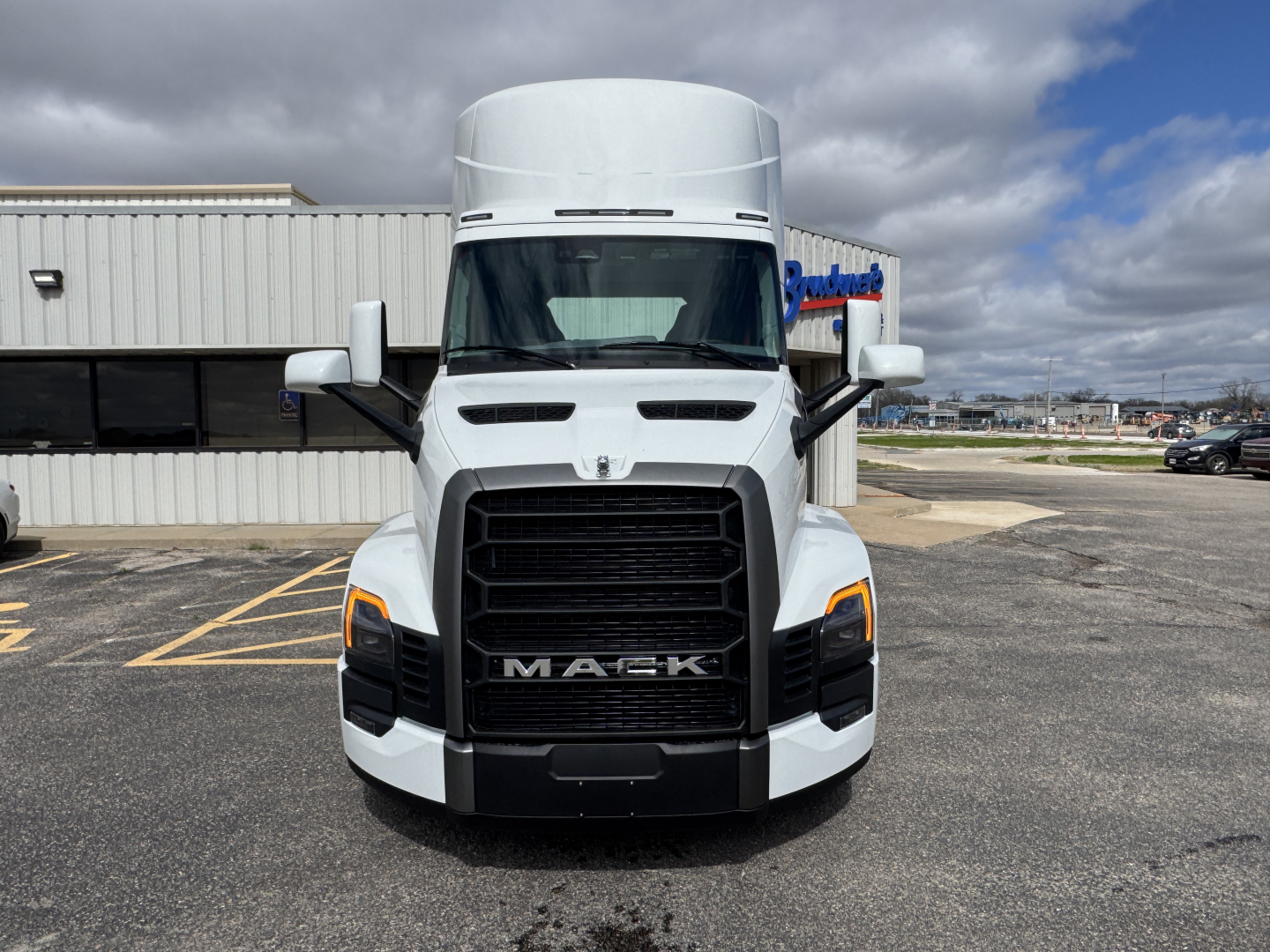 Mack PR64T truck front view showing bold grille, headlights, and side mirrors.