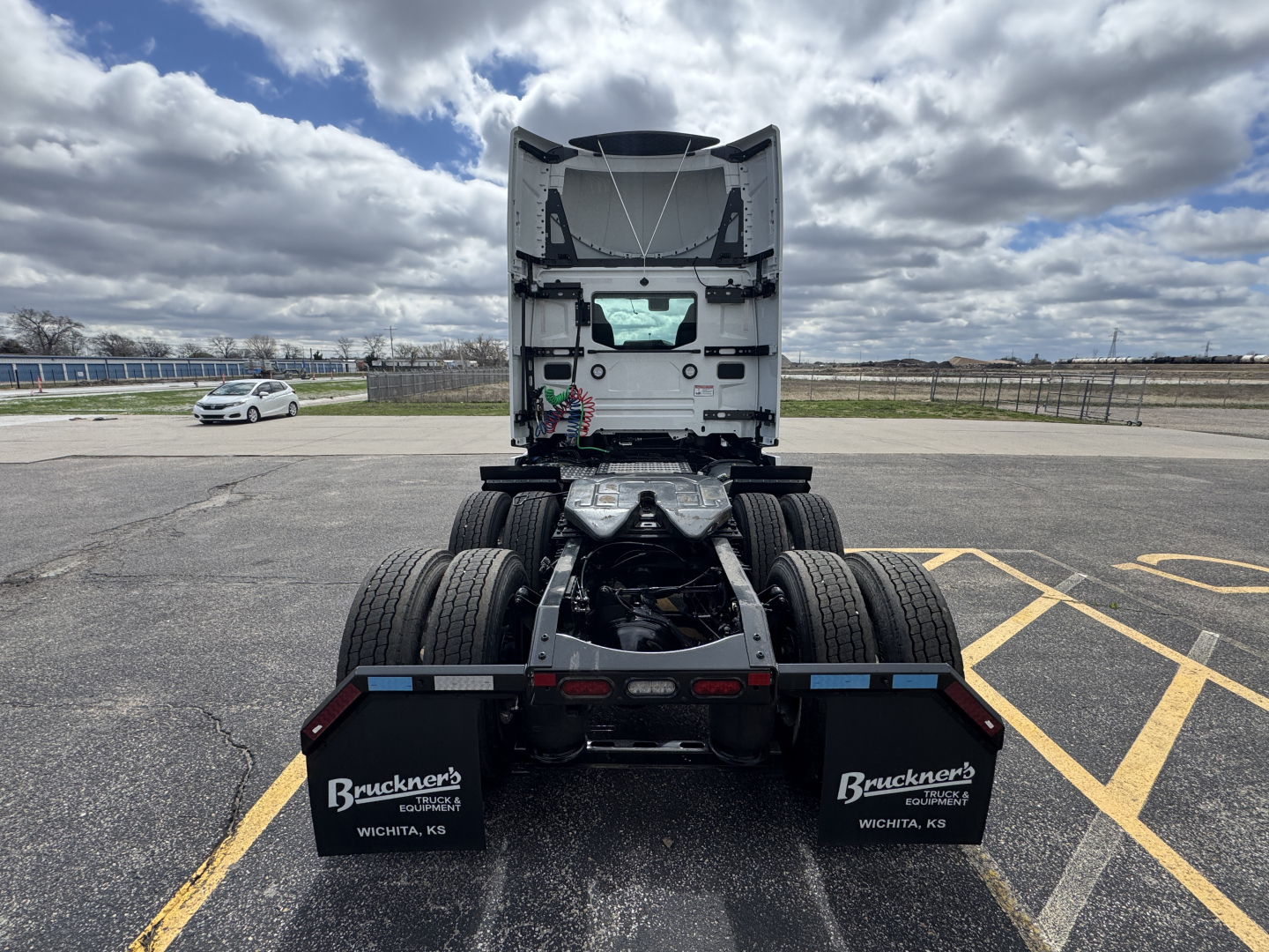 Rear view of a 2026 Mack PR64T tractor showing the fifth wheel and dual rear axles; empty cab with exposed components and mud flaps citing Bruckners Wichita, KS.
