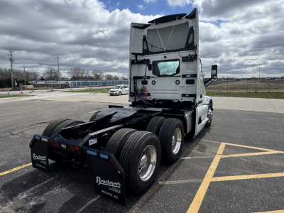 Truck cab rear and chassis of a 2026 Mack PR64T tractor seen from rear left angle in a parking lot; no visible text on side; rear shows tires and braking components.