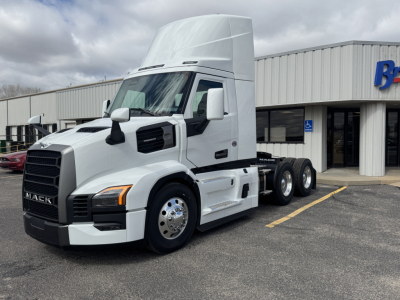 Mack PR64T tractor unit in white, side view showing cab and dual rear axles, front grille with Mack logo, daycab configuration.