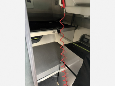Volvo VNL 840 sleeper cab interior with metallic storage compartments and red coiled air line in foreground.