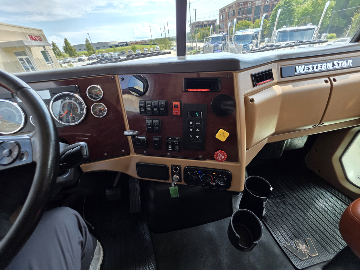 Dashboard of a 2022 Western Star 4700SF truck showing instrument cluster, center control panel, steering wheel, beige and black interior, Western Star branding on dash.