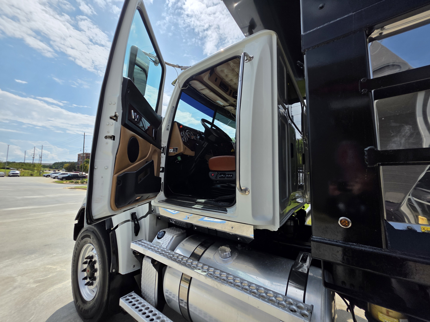 Vehicle cab interior and steps of a 2022 Western Star 4700SF dump truck showing open door and entry steps.