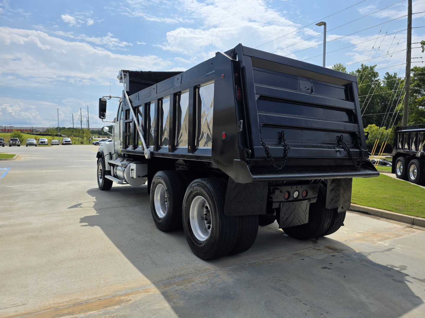 2022 Western Star 4700SF dump truck rear and side view showing dump bed and dual rear axles.