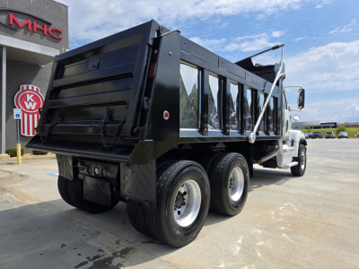 Truck bed of a Western Star 4700SF dump truck viewed from rear-left showing dual rear axles and black dump body.