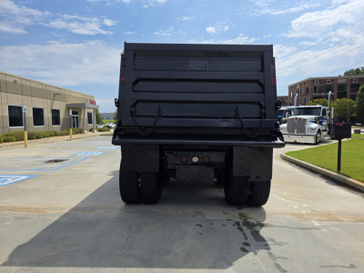 Western Star 4700SF dump truck rear view showing dump bed tailgate and dual rear wheels.