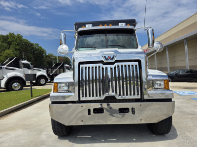 Front view of a chrome Western Star 4700SF truck with large grille, bumper, and mirrors in a dealership lot.