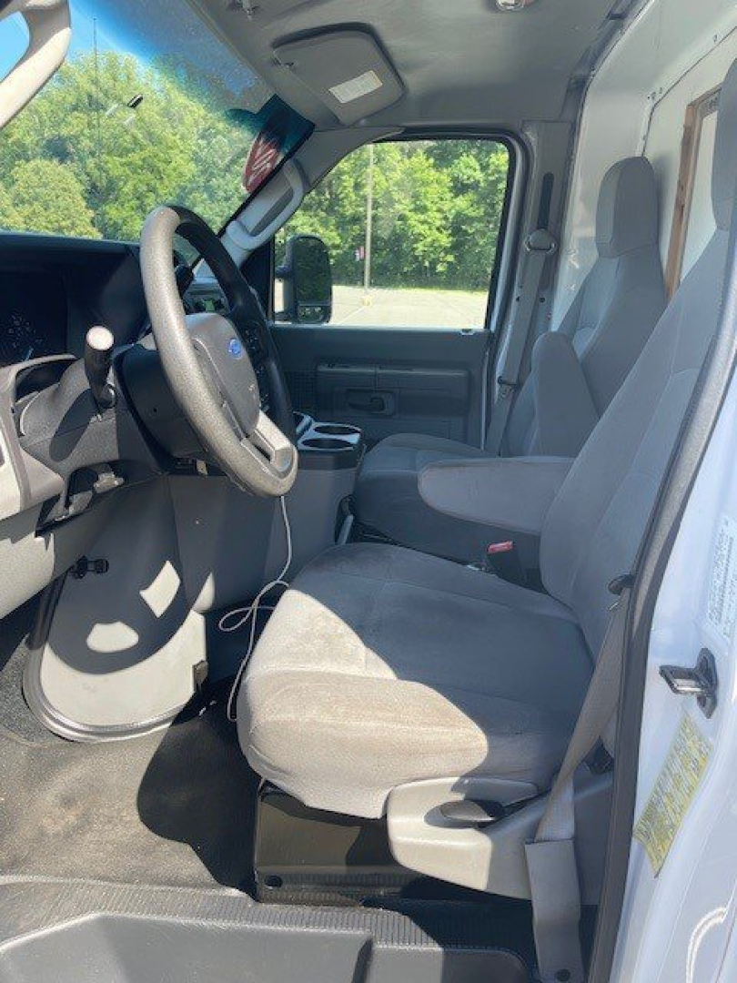 Ford E-Series Cutaway cab interior showing driver and passenger seats, steering wheel, and dashboard in view.