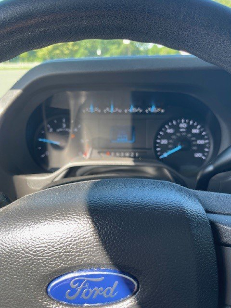 Ford steering wheel with Ford logo and instrument cluster in background.