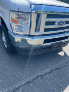 Front view of a Ford E-Series Cutaway box truck showing chrome grille, Ford emblem, headlight assembly, and front bumper.