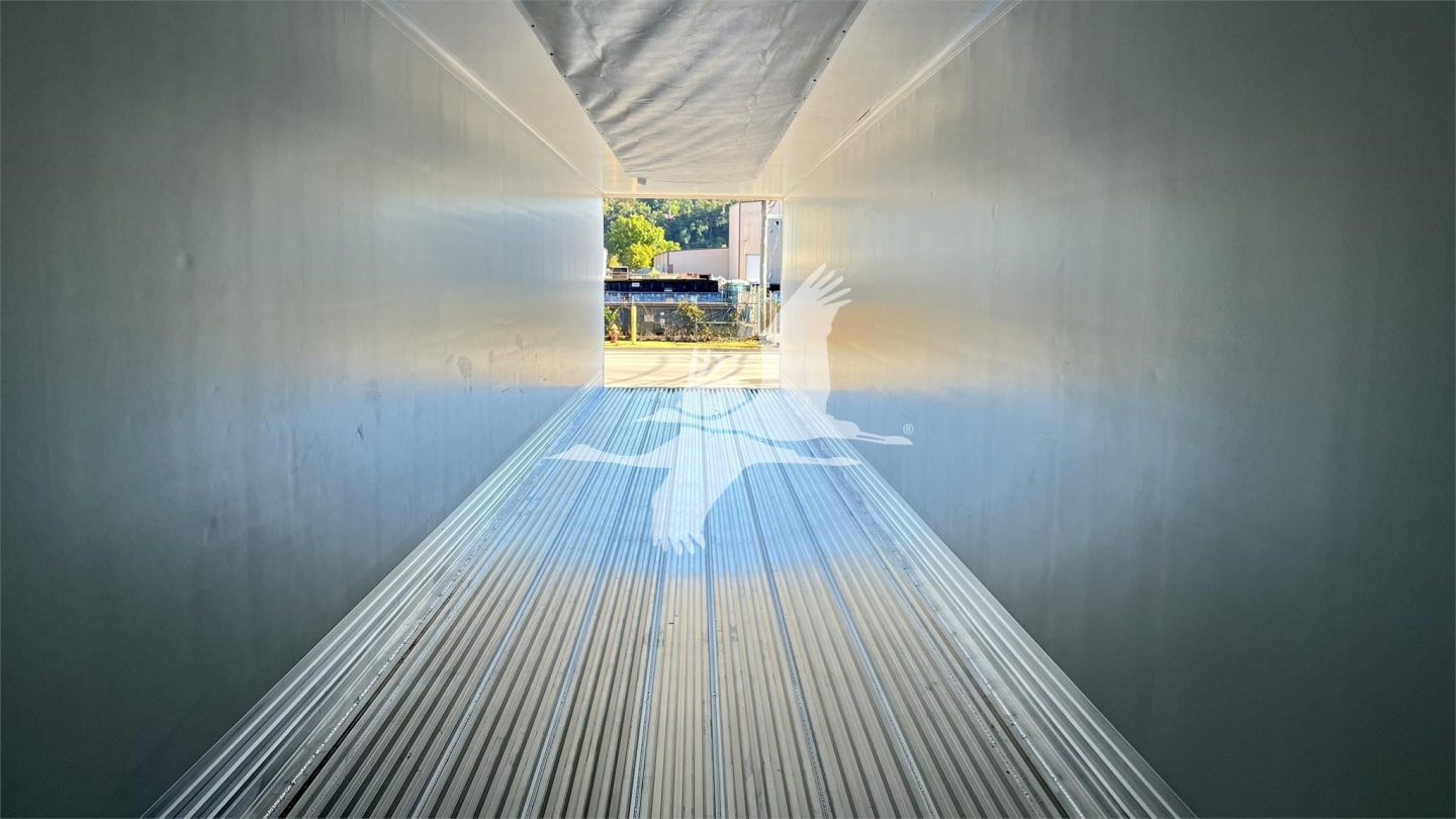 Interior view of a Vanguard globe reefer trailer showing a long metallic floor and forward opening into daylight.