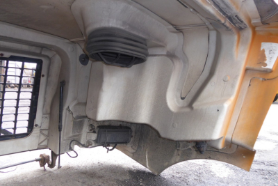 Volvo VNM hood area showing engine bay component with large pulley and grey reservoir cap.