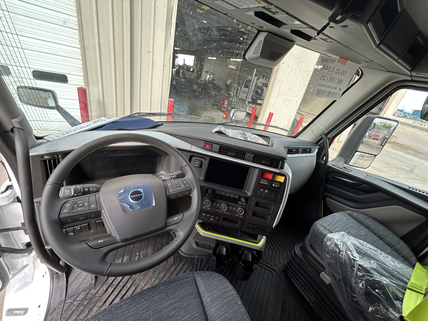 Cab interior of a 2026 Volvo VNL64T860 showing steering wheel, dashboard, and center console with control buttons and touchscreen.