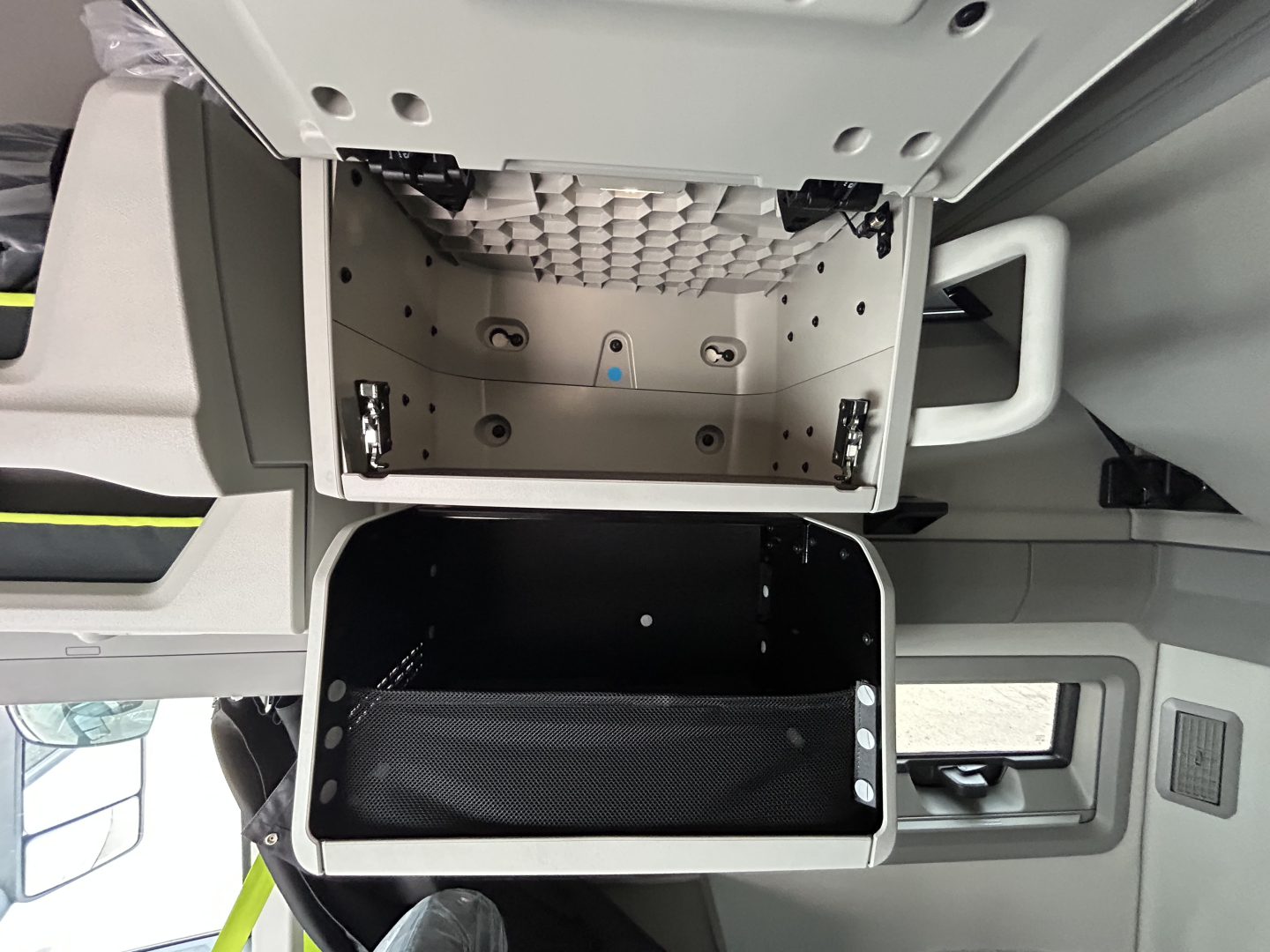 Volvo VNL64T860 cab interior showing overhead storage compartments and a lower storage bin in the sleeper area.