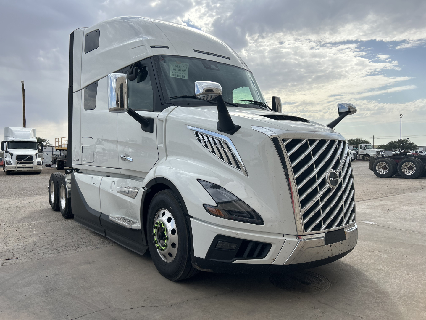 Volvo VNL64T860 truck in white, forward view showing distinctive grille, large mirrors, sleeper cab, and chrome accents.