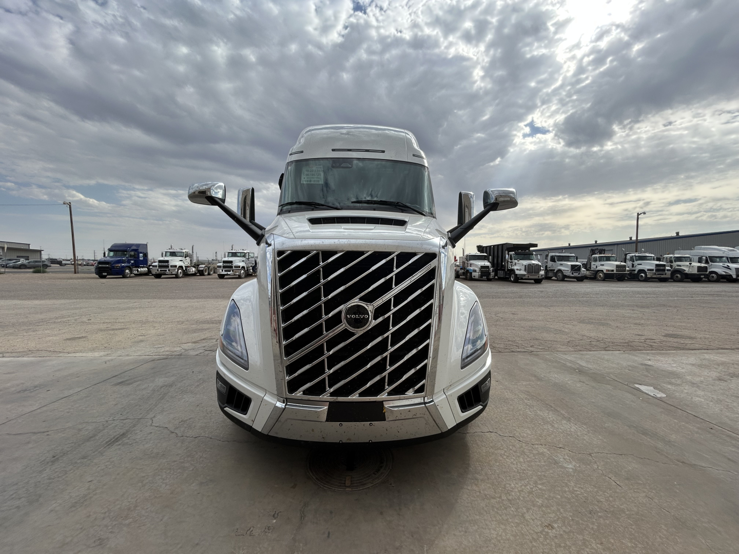 Front view of a white Volvo VNL64T860 truck cab in a parking lot