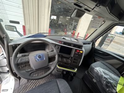 Cab interior of a 2026 Volvo VNL64T860 showing steering wheel, dashboard, and center console with control buttons and touchscreen.