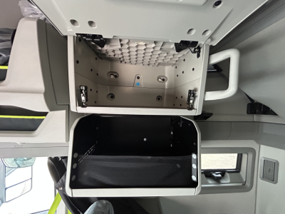 Volvo VNL64T860 cab interior showing overhead storage compartments and a lower storage bin in the sleeper area.