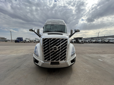 Front view of a white Volvo VNL64T860 truck cab in a parking lot