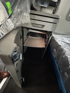 Interior of a new Volvo VNL64T860 truck cab showing open compartment with shelves and storage area under dash.