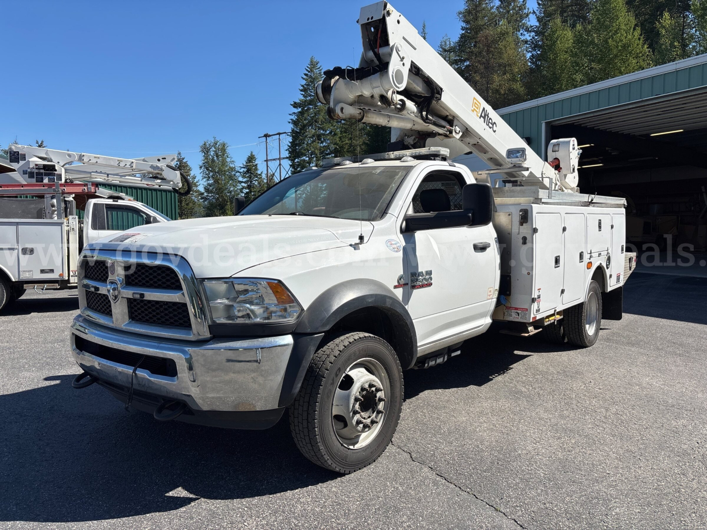 2014 Dodge Ram 5500 bucket truck with mounted boom lift, white cab and service utility body, front grille, wheels visible.