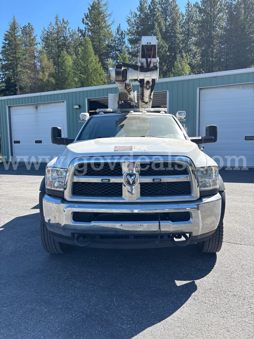 Dodge Ram 5500 bucket truck front view with crane equipment on roof showing grille and bumper.