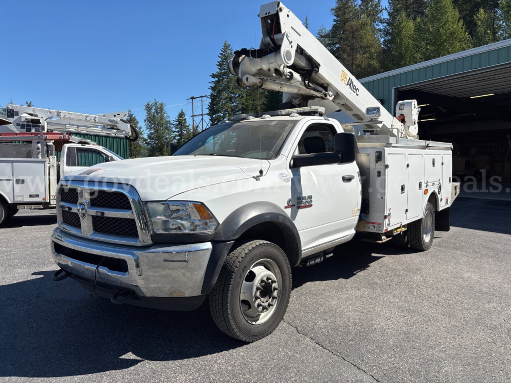 2014 Dodge Ram 5500 bucket truck with mounted boom lift, white cab and service utility body, front grille, wheels visible.