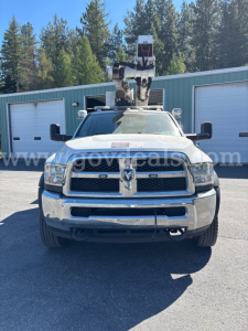 Dodge Ram 5500 bucket truck front view with crane equipment on roof showing grille and bumper.