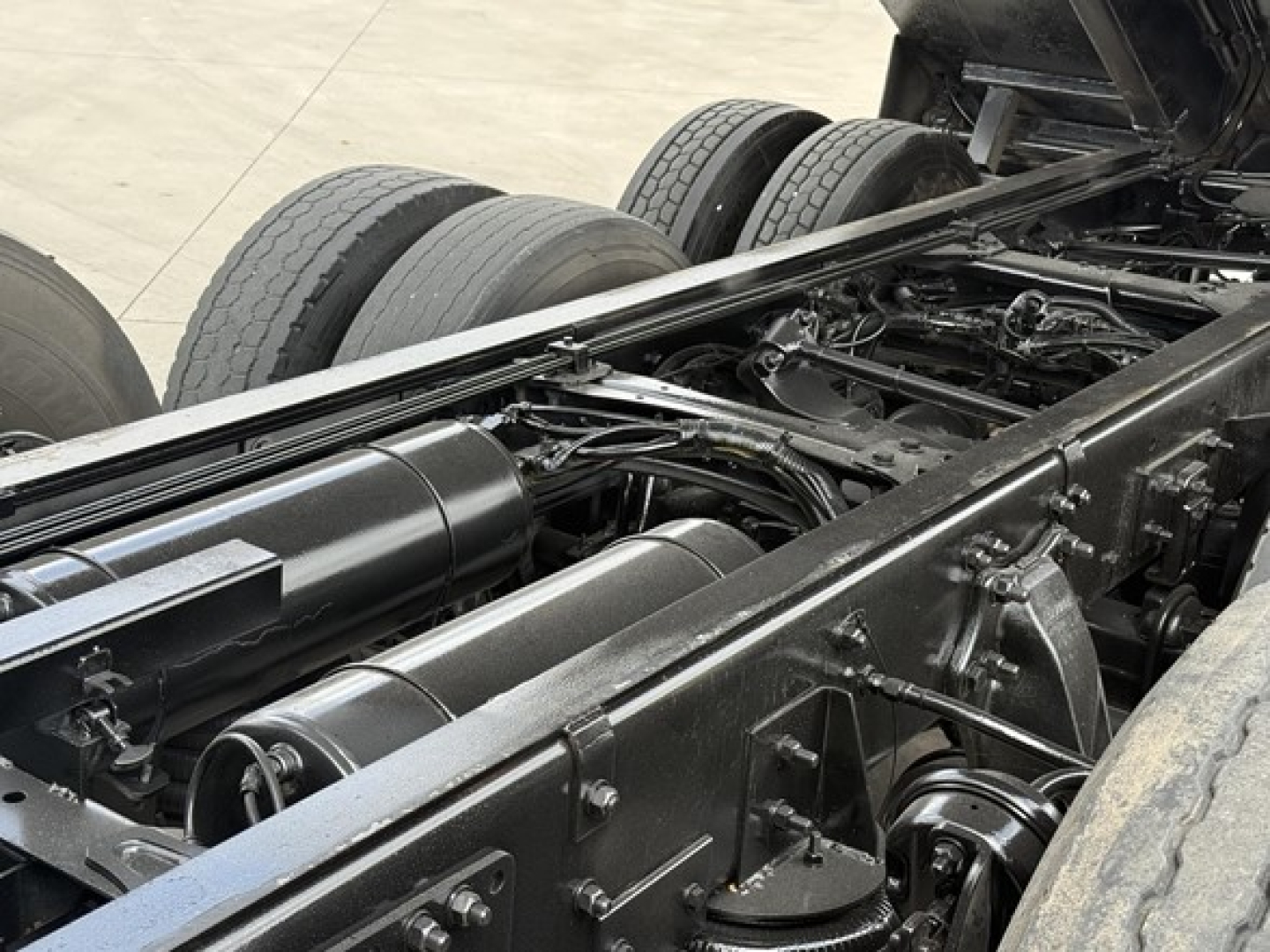 Freightliner 122SD chassis frame and drivetrain view showing undercarriage with multiple axles and tires.