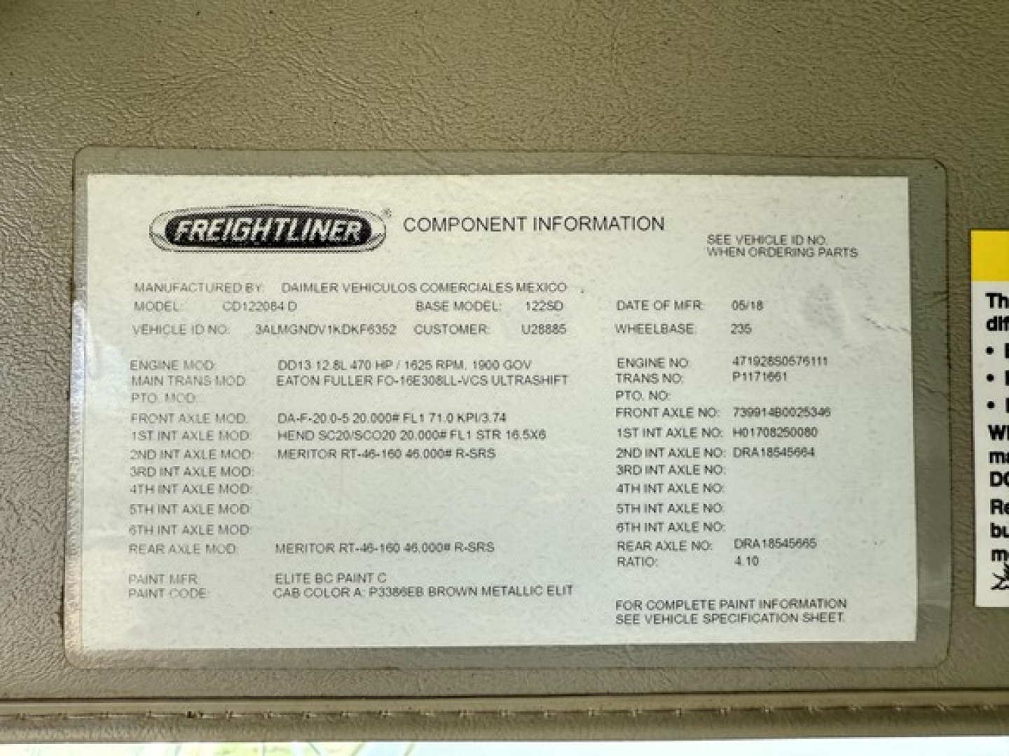 Freightliner component information plate on a diesel truck showing model, engine, transmission, axle mods and paint codes.