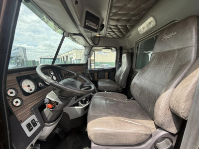 Freightliner 122SD truck interior showing steering wheel, dashboard gauges, and front seats.