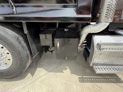 Freightliner 122SD undercarriage showing fuel/air lines and toolbox along side of engine bay in cab area.