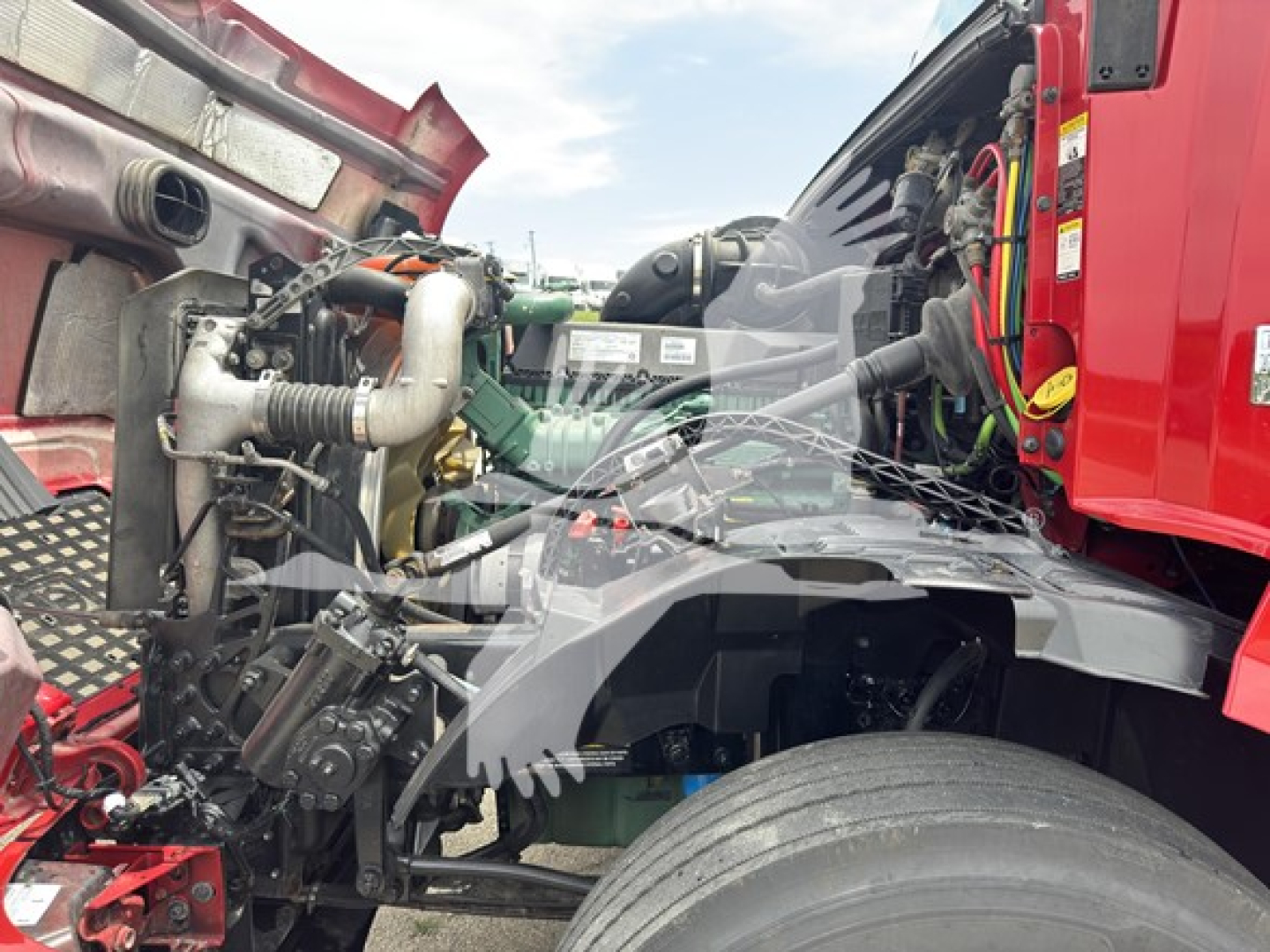 Volvo engine bay with visible components and hoses in a truck cab area.