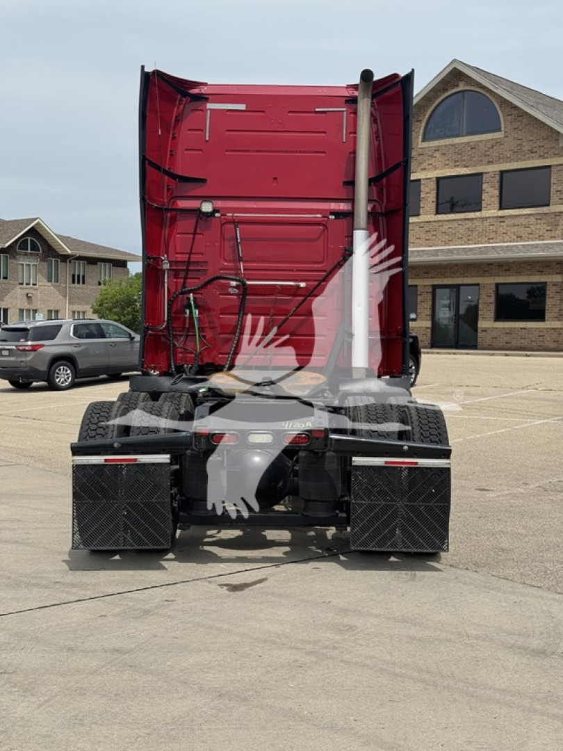 Truck rear view showing fifth-wheel hitch and dual exhaust pipes of a red 2018 Volvo VNL64T670 sleeper cab tractor.