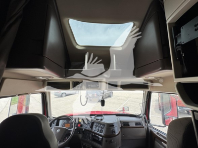 Cab interior view of a Volvo VNL truck showing dashboard, steering wheel, and overhead sleeper area; includes watermark overlay.