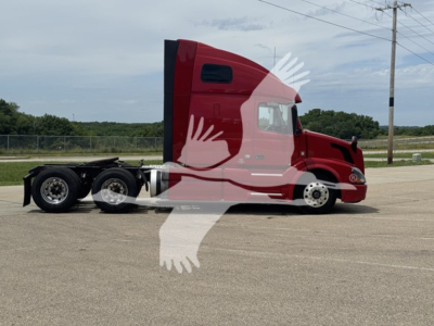 Volvo VNL64T670 sleeper cab tractor tractor with red paint side view showing cab and rear wheels.