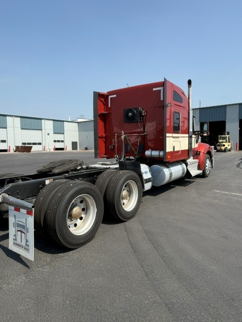 Kenworth W990 tractor rear view showing sleeper cab and dual rear axles with wheels