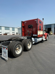 Kenworth W990 tractor rear view showing sleeper cab and dual rear axles with wheels