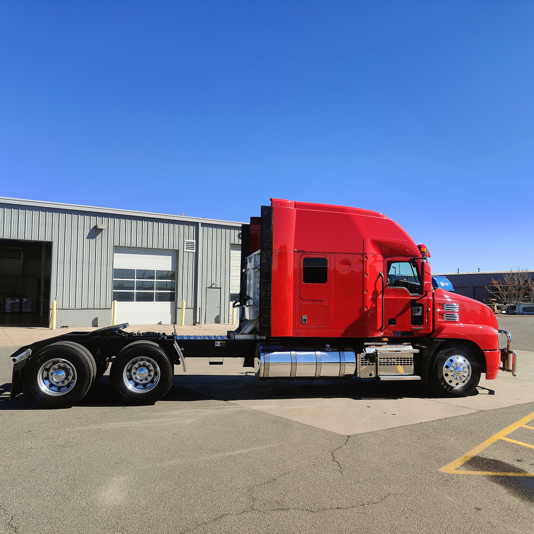Red Mack AN64T70 truck in side profile showing sleeper cab, chassis, and dual rear axles.