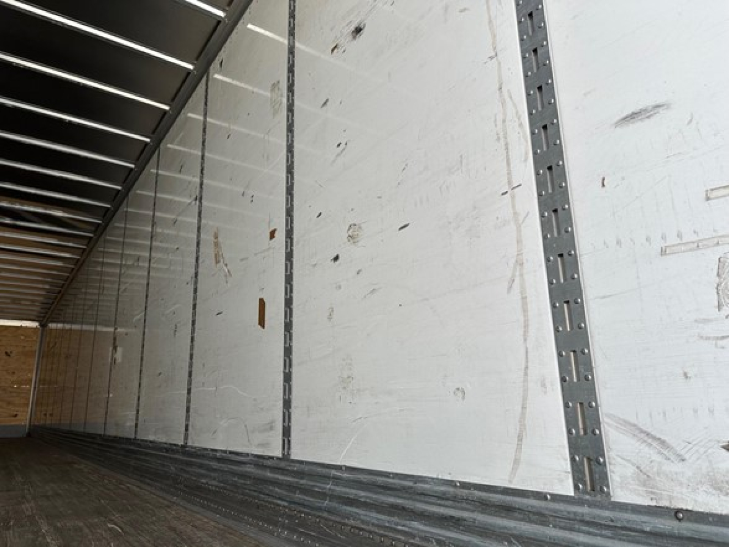 Trailer interior wall and floor of a 2022 Great Dane Champion trailer showing sidewall panels and steel stanchions.