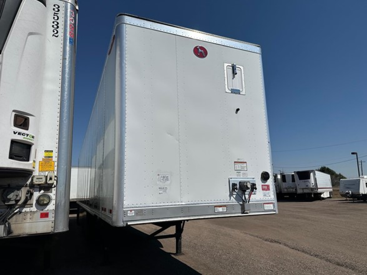 Trailer hitch area of a 2022 Great Dane Champion van trailer showing a rear door and brand badge.