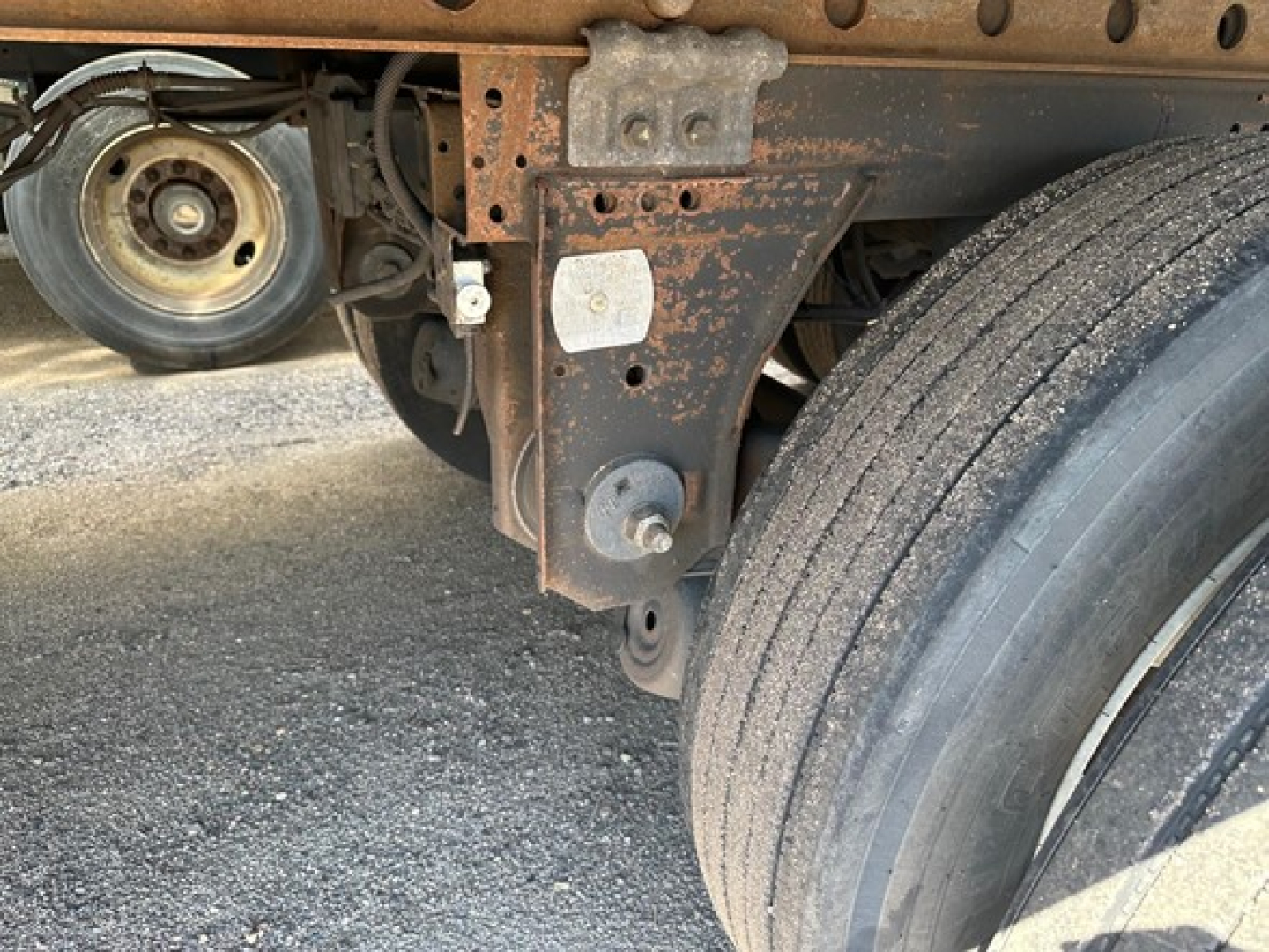 Great Dane Champion trailer undercarriage showing rusted frame, suspension components, and dual tires with wheel chocks.
