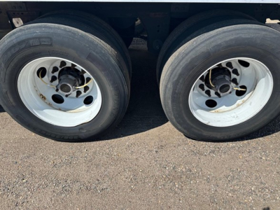 Dual trailer wheels and tires on a Great Dane Champion trailer show white rims and black tires undercarriage.