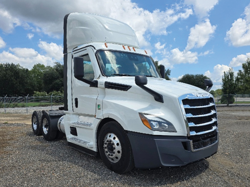 Freightliner Cascadia126 tractor in a parking lot showing front and side view with white cab and black bumper, no visible text on components.